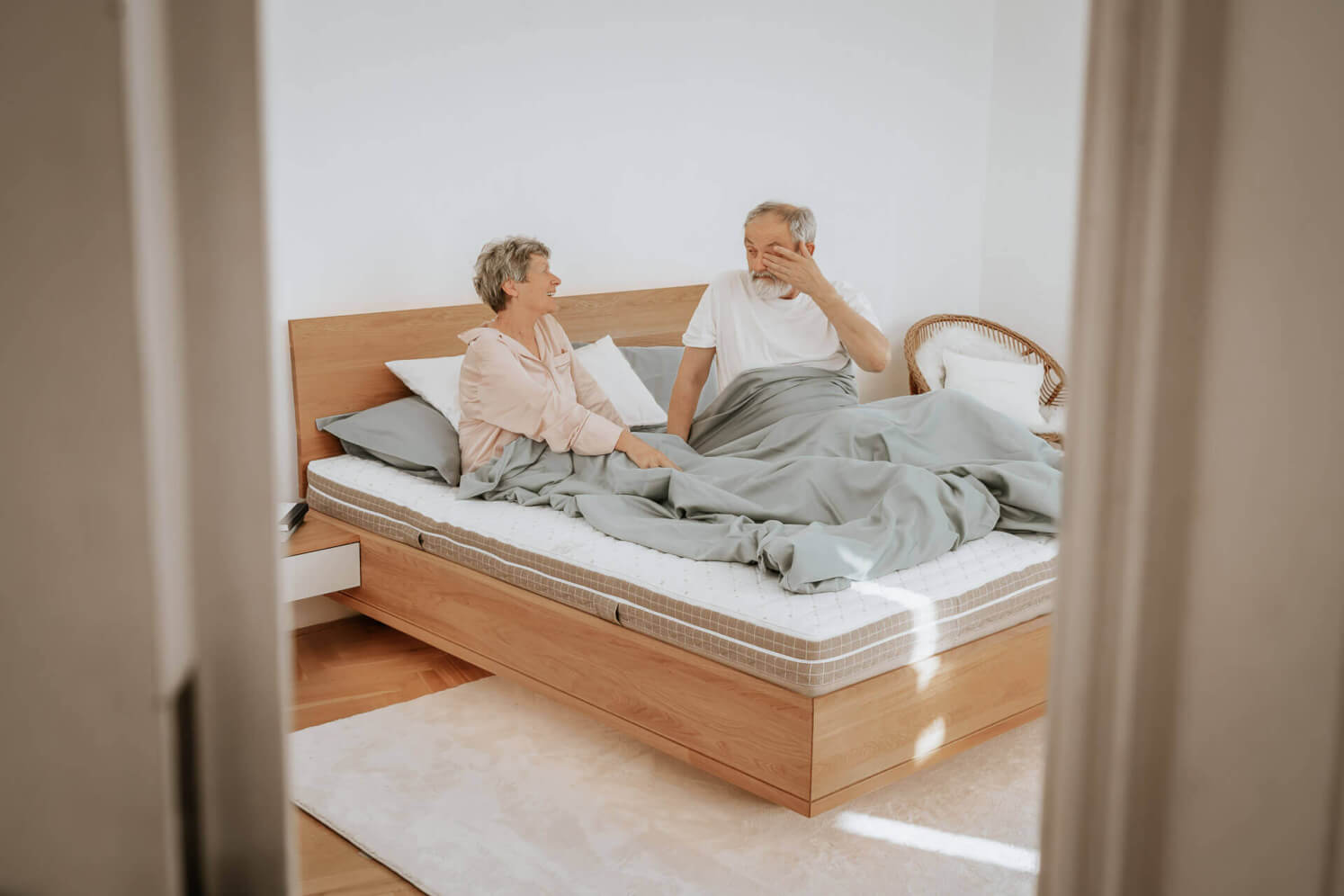 Ein älteres Ehepaar steht von seiner SÁRA Spirit-Matratze mit Morrison-Bezug auf. Die Maße der einzelnen Matratzen auf dem Foto betragen 90 x 200 x 22 cm.
